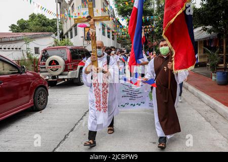 Manila, Philippinen. 12.. Juni 2022. Mitglieder einer religiösen Gemeinde pilgern anlässlich des 124.. Jahrestages der Unabhängigkeit der Philippinen in Quezon City, Metro Manila, Philippinen. 12. Juni 2022. Die Wallfahrt wurde vom philippinischen katholischen Priester P. Robert Reyes markiert die Dauer des Christentums im Land. (Bild: © Basilio Sepe/ZUMA Press Wire) Stockfoto