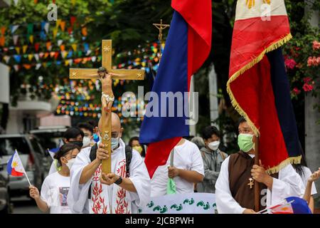 Manila, Philippinen. 12.. Juni 2022. Mitglieder einer religiösen Gemeinde pilgern anlässlich des 124.. Jahrestages der Unabhängigkeit der Philippinen in Quezon City, Metro Manila, Philippinen. 12. Juni 2022. Die Wallfahrt wurde vom philippinischen katholischen Priester P. Robert Reyes markiert die Dauer des Christentums im Land. (Bild: © Basilio Sepe/ZUMA Press Wire) Stockfoto