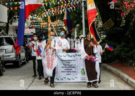 Manila, Philippinen. 12.. Juni 2022. Mitglieder einer religiösen Gemeinde tragen philippinische Flaggen, während sie eine Pilgerfahrt zum 124.. Jahrestag der Unabhängigkeit der Philippinen in Quezon City, Metro Manila, Philippinen, abhalten. 12. Juni 2022. Die Wallfahrt wurde vom philippinischen katholischen Priester P. Robert Reyes markiert die Dauer des Christentums im Land. (Bild: © Basilio Sepe/ZUMA Press Wire) Stockfoto