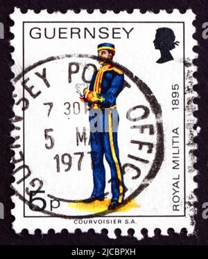 GUERNSEY - UM 1974: Eine in der Guernsey gedruckte Marke zeigt die königliche Miliz, Uniform von 1895, um 1974 Stockfoto