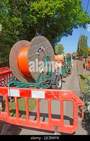 Superschnelles Breitbandinfrastrukturprojekt mit Glasfasertechnik in ländlichen Essex-Dorfkabeln auf Trommeln für die Verlegung in neuen flachen Straßengräben England Großbritannien Stockfoto