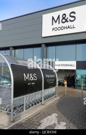 M&S Foodhall Retail Business Logo & Markenschild über Ladeneingang überdachte Marken und Spencers Supermarkt Shopping Trolley Schutz Essex England UK Stockfoto