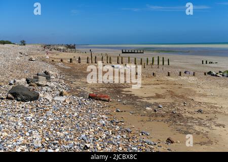 Der Kletterstrand in West Sussex bei Ebbe zeigt die Anzeichen von Winterstürmen mit beschädigten Meeresabwehrungen. Stockfoto