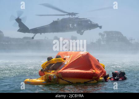 Apr 19, 2022 - Camp Pendleton, Kalifornien, USA - US Naval Aircrewmen von einem MH-60s Seahawk Hubschrauber eingesetzt, der den Wildcards des Helicopter Sea Combat Squadron (HSC) 23 zugewiesen wurde, Und die US-Marine, die der Marine Division 1. zugewiesen wurde, während einer Veranstaltung zur Personalerholung in Camp Pendleton, Kalifornien, am 19. April 2022 wieder zu erlangen. Während der Evolution, die von HSC-3, dem Chef der Marineoperationen (CNO) Search and Rescue Model Manager (SARMM), beaufsichtigt wurde, nahm HSC-23 an einem dynamischen Proof-of-Concept-Event Teil, bei dem zwei MH-60s-Hubschrauber Such- und Rettungseinsätze zur Rückgewinnung großer Tonnen durchführten Stockfoto