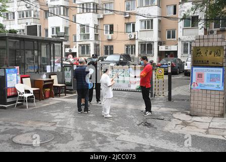 Peking, China. 12.. Juni 2022. Bewohner scannen QR-Codes, um ihren Gesundheitszustand am Eingang eines Wohngebiets in Zhongguancun im Bezirk Haidian, Peking, der Hauptstadt Chinas, registrieren zu lassen, 12. Juni 2022. Das Pekinger Gebiet Zhongguancun hat vor kurzem bei einem Ausbruch strengere COVID-19-Präventions- und -Kontrollmaßnahmen eingeführt. Auf Gemeindeebene gehören dazu eine strengere Registrierung von Besucherinformationen, die Verfolgung von Gesundheitscodes, eine Temperaturkontrolle und die Verifizierung negativer COVID-19-Testergebnisse. Quelle: Ren Chao/Xinhua/Alamy Live News Stockfoto