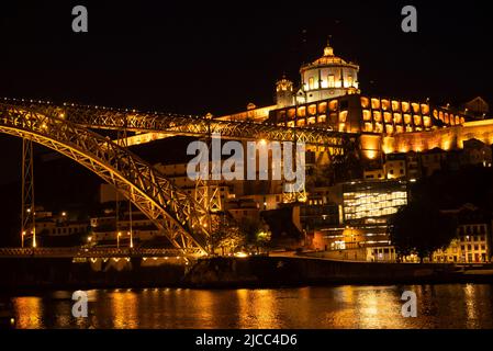 Nachtaufnahme von Porto mit Blick auf Vila Nova de Gaia, mit der beleuchteten Brücke „Ponte Dom Luís I“ und dem Kloster Serra do Pilar Stockfoto