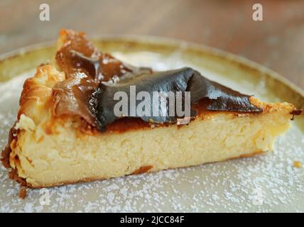 Nahaufnahme ein Stück köstlichen hausgemachten baskischen Käsekuchen auf Clayware-Teller Stockfoto