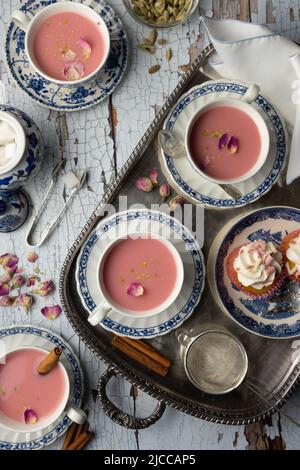 Kashmiri Pink Chai serviert in einem blau-weißen Teeset Stockfoto