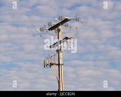 Hochspannungsleitungen in einem blauen Himmel und Wolken. Stockfoto