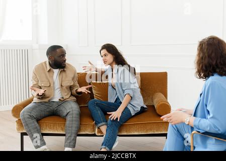 Betont unglücklich Millennial kaukasischen und afroamerikanischen Paar haben Beziehungsprobleme. Verschiedene Paare kämpfen, während sie professionell zu Besuch sind Stockfoto