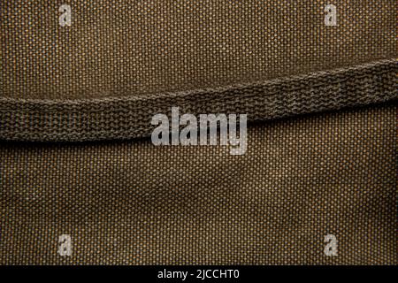 Nahaufnahme Textur eines Rucksack aus Canvas-Stoff. Lederriemen und Metallschnallen. Vintage Khaki Hintergrund. Stockfoto