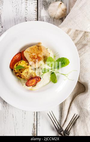 Draufsicht putenschnitzel und gegrilltes Gemüse. Köstliche und gesunde hausgemachte Speisen. Käsesauce mit Knoblauch und Olivenöl. Essen Stillleben auf weiß Stockfoto