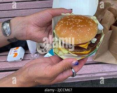 Moskau, Russland. 12.. Juni 2022. Ein Mann hält einen Burger vom russischen McDonald's-Nachfolger in Moskau. Kredit: Hannah Wagner/dpa/Alamy Live Nachrichten Stockfoto