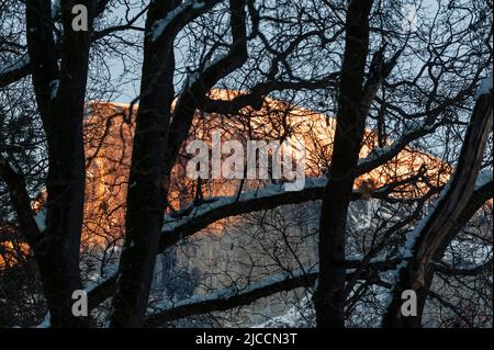 Teleaufnahme einer verschneiten Halbkuppel, die an einem Winterabend die letzten Sonnenstrahlen einfängt. Stockfoto