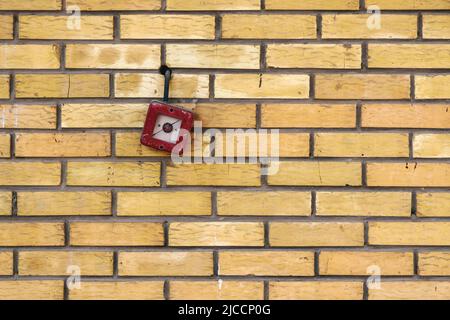 Vintage-Feueralarm-Box an der Ziegelwand mit Kopierraum montiert Stockfoto