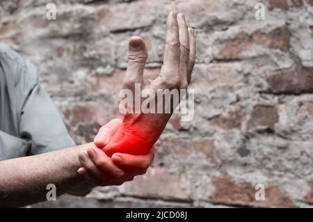 Entzündung des asiatischen alten Mann Handgelenks. Konzept von Gelenkschmerzen und Handproblemen. Stockfoto