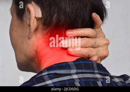 Schmerzen im Nackenmuskel des südostasiatischen älteren Mannes. Konzept von Nackenschmerzen und Nackensteifigkeit. Stockfoto