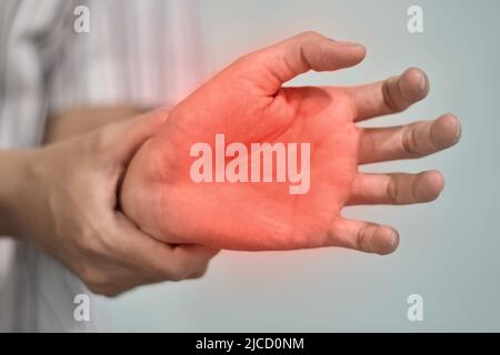 Schmerzhafter Palmar-Aspekt des asiatischen jungen Mannes. Konzept des Kompartiment-Syndroms, Zellulitis und Schmerzen der Handmuskulatur. Stockfoto