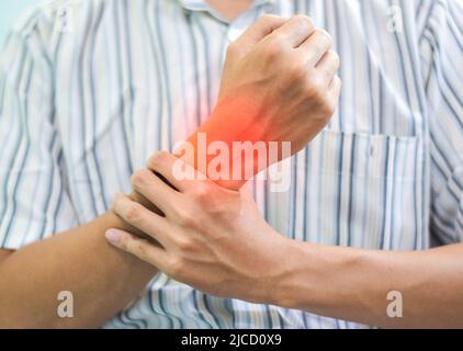 Entzündung des asiatischen jungen Mannes Handgelenk. Konzept von Gelenkschmerzen und Handproblemen. Stockfoto