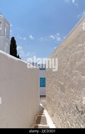 Blick auf das Bergdorf Megalo Chorio, Tilos, enge Gasse zwischen zwei unberührten, weiß getünchten Wänden. Dodekanesisch, Rhodos, Griechenland Stockfoto