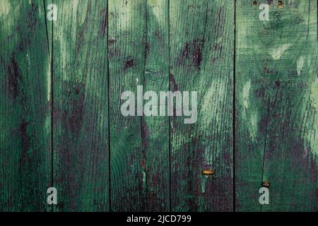 Alte, verzweifelte Holzwand mit abgenutzter, grün abblätternder Farbe und grungenem Holzhintergrund Stockfoto