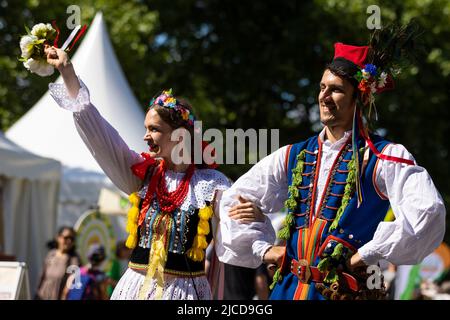 Hannover, Deutschland. 12.. Juni 2022. Mitglieder der polnischen Folkloregruppe „Polonia“ gehen während der „Parade der Vielfalt“ am Niedersächsischen Tag 37. am Publikum vorbei. Quelle: Moritz Frankenberg/dpa/Alamy Live News Stockfoto