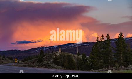 Ein schöner roter Sonnenuntergang über den Bergen, die von Nadelwäldern überwuchert sind. USA Stockfoto