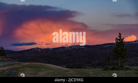 Ein schöner roter Sonnenuntergang über den Bergen, die von Nadelwäldern überwuchert sind. USA Stockfoto