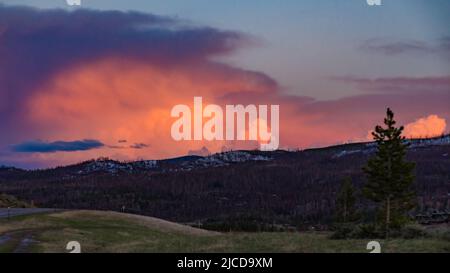 Ein schöner roter Sonnenuntergang über den Bergen, die von Nadelwäldern überwuchert sind. USA Stockfoto