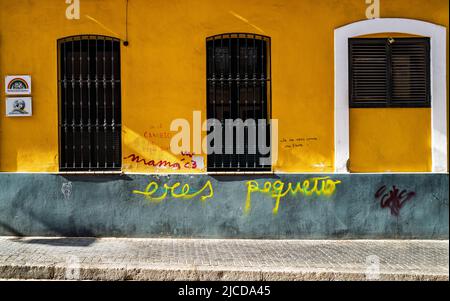 Macarena, Sevilla, Spanien -- 11. Juni 2022. Eine Weitwinkelaufnahme einer ockerfarbenen Wand und Graffiti im Macarena-Teil von Sevilla, Spanien. Stockfoto