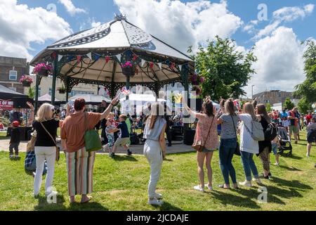 Live-Musik in Princes Gardens Bandstand, Aldershot, Hampshire, England, Großbritannien. Die Leute genießen die Unterhaltung beim Victoria Day Event, 2022. Juni Stockfoto