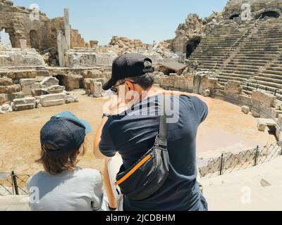 Der junge Vater Vater und sein Schuljunge Sohn Touristen besuchen alte antike kolosseum Amphitheater Ruinen an heißen Sommertagen Stockfoto