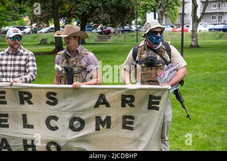 11. Juni 2022, Coeur d' Alene, Idaho, USA: Bewaffnete Männer halten ein Transparent mit der Aufschrift "Groomers are not Welcome in Idaho", während sie gegen den jährlichen "Pride in the Park march at Mceuen Park in Downtown Coeur d'Alene, Idaho, protestieren. Die Polizei in Coeur d'Alene verhaftete am Samstag 31 maskierte Mitglieder der weißen nationalistischen Gruppe Patriot Front, die laut dem Polizeichef von Coeur d'Alene angeblich „zu Unruhen in der Innenstadt kamen“. (Bild: © Jacob Lee Green/ZUMA Press Wire Service) Stockfoto