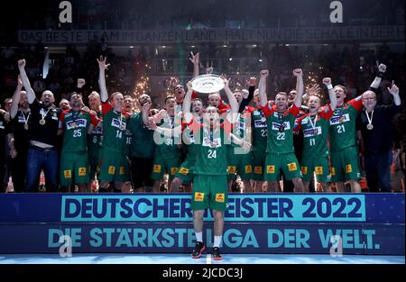 Magdeburg, Deutschland. 12.. Juni 2022. Handball: Bundesliga, SC Magdeburg - Rhein-Neckar Löwen, Matchday 34, GETEC Arena Christian O'Sullivan (M) aus Magdeburg hält den Pokal während der WM-Zeremonie vor seinen Teamkollegen. Quelle: Ronny Hartmann/dpa/Alamy Live News Stockfoto