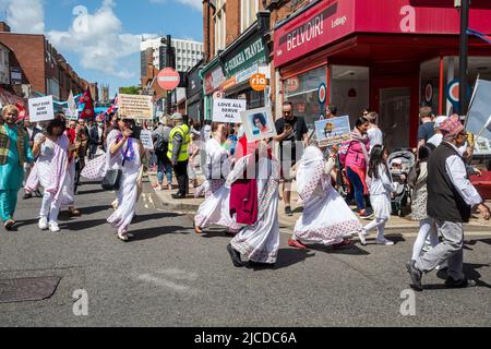 Die Grand Parade am Victoria Day, eine jährliche Veranstaltung in Aldershot, Hampshire, England, Großbritannien. Anhänger des indischen Gurus Sathya Sai Baba, der daran teilnimmt. Stockfoto