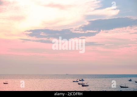 Wunderschöner Sonnenaufgang auf Meeresgrund mit tropischem Holzfischboot in rosa Tönen Stockfoto