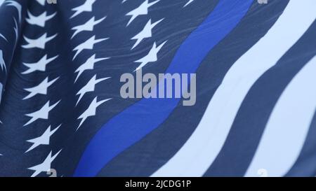 Schwarz-weiße amerikanische monochrome Flagge mit blauem Streifen oder Linie, Polizeiunterstützung. Solides, sternenbespanntes Banner, das in der Windbrise winkt. Stockfoto