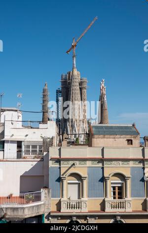 Barcelona, Spanien - 29. Mai 2022: Blick auf die Kathedrale Sagrada Familia in Barcelona hinter der Fassade eines schönen Gebäudes. Stockfoto