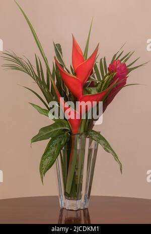 Wunderschöne tropische Blumenarrangements in einer Kristallvase Stockfoto