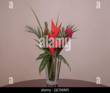 Wunderschöne tropische Blumenarrangements in einer Kristallvase Stockfoto