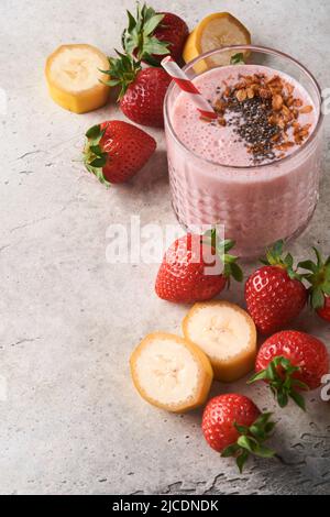 Erdbeer-Smoothie. Veganer Smoothie oder Milchshake aus Erdbeere, Banane und Minze auf weißem Holztischhintergrund. Saubere Ernährung, alkalische Ernährung. Obere V Stockfoto