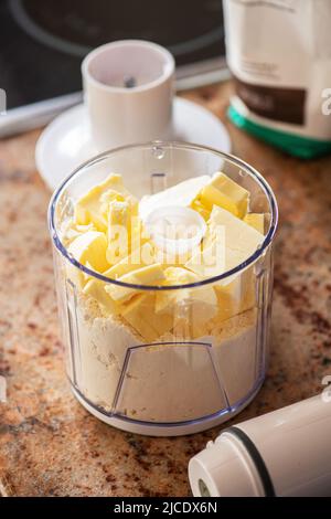 Blätterteig in der Zubereitung, Mehl und Butter in einem Mixbecher. Küchengeräte, Home Style Konzept. Stockfoto