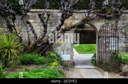 Tor, das zu einer Pfanterie, einem Kräutergarten-Spaziergang und einem Naturlehrpfad in den Sudeley Castle Gardens, Sudeley, Gloucestershire, Cotswolds, England, führt, VEREINIGTES KÖNIGREICH. Stockfoto