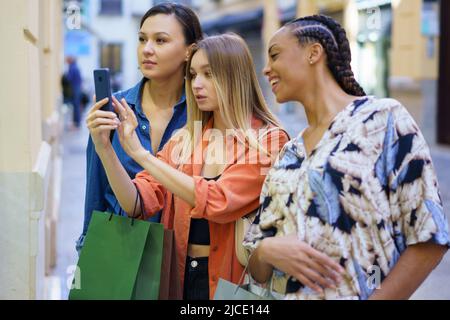 Multirassische Frauen, die auf dem Smartphone eine Vitrine fotografieren Stockfoto