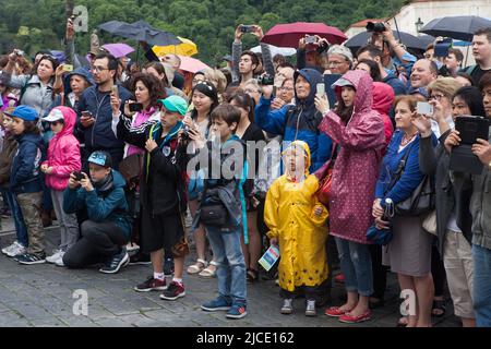 Touristen warten auf die Zeremonie der Wachablösung (Hradní Stráž) vor der Prager Burg auf dem Hradčanské-Platz in Prag, Tschechische Republik. Stockfoto