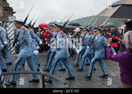 Touristen beobachten die Zeremonie der Wachablösung (Hradní Stráž) bei Regen vor der Prager Burg auf dem Hradčanské-Platz in Prag, Tschechische Republik. Stockfoto