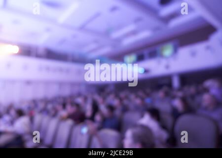 Veranstaltungssaal mit Stühlen auf verschwommenem Hintergrund. Das Publikum eines Musikkonzerts oder eines Konferenzsaals für Seminare im Bildungs- und Kreativbereich. Hochwertige Fotos Stockfoto