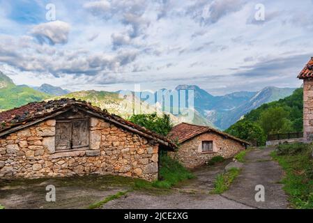 Typische Steinhäuser auf der Spitze der asturischen Berge, mit einem Hintergrund von Berggipfeln. Asturien. Stockfoto