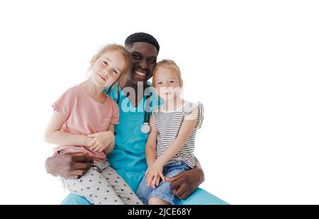 Ein amerikanischer Kinderarzt umarmt zwei kleine Mädchen, die auf seinem Schoß auf weißem Hintergrund sitzen Stockfoto