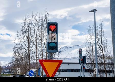 Kreatives, herzförmiges Stopplicht im Verkehrssignal gegen den Himmel in der Stadt Stockfoto